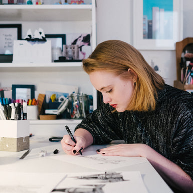 Femme dessinant à son bureau