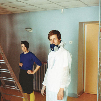 Femme en blouse blanche, homme en bleu, escalier, pièce