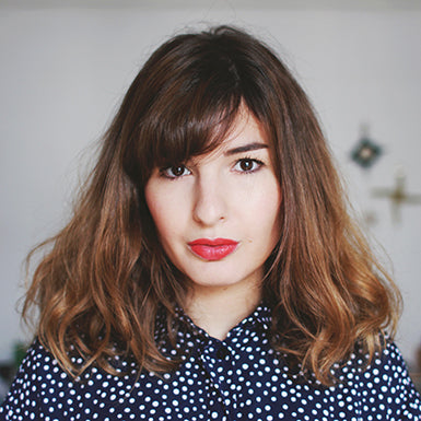 Femme aux cheveux bruns, lèvres rouges, chemise à pois, fond blanc